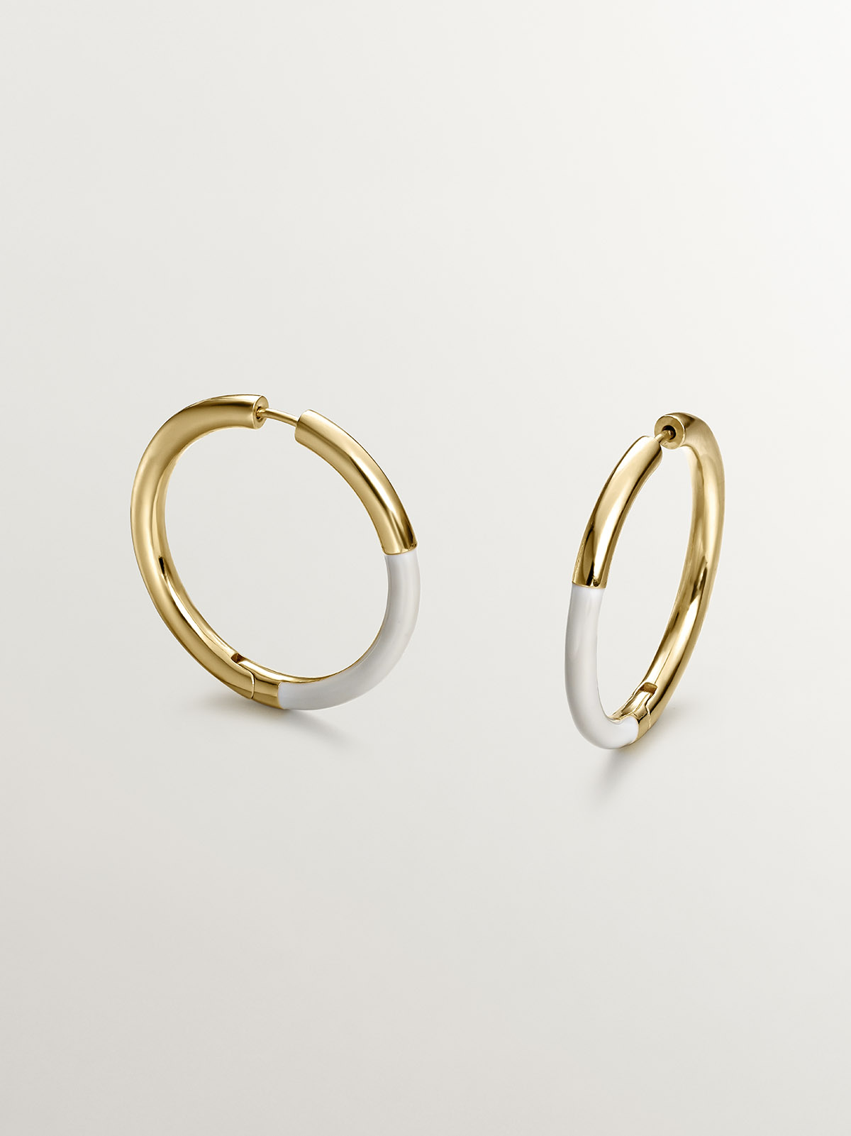 Large hoop earrings made of 925 silver coated in 18K yellow gold with white enamel.
