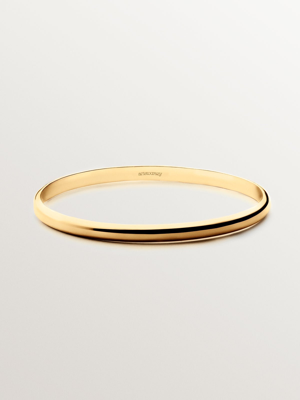 Pulsera rígida estilo semanario de plata 925 bañada en oro amarillo de 18K.