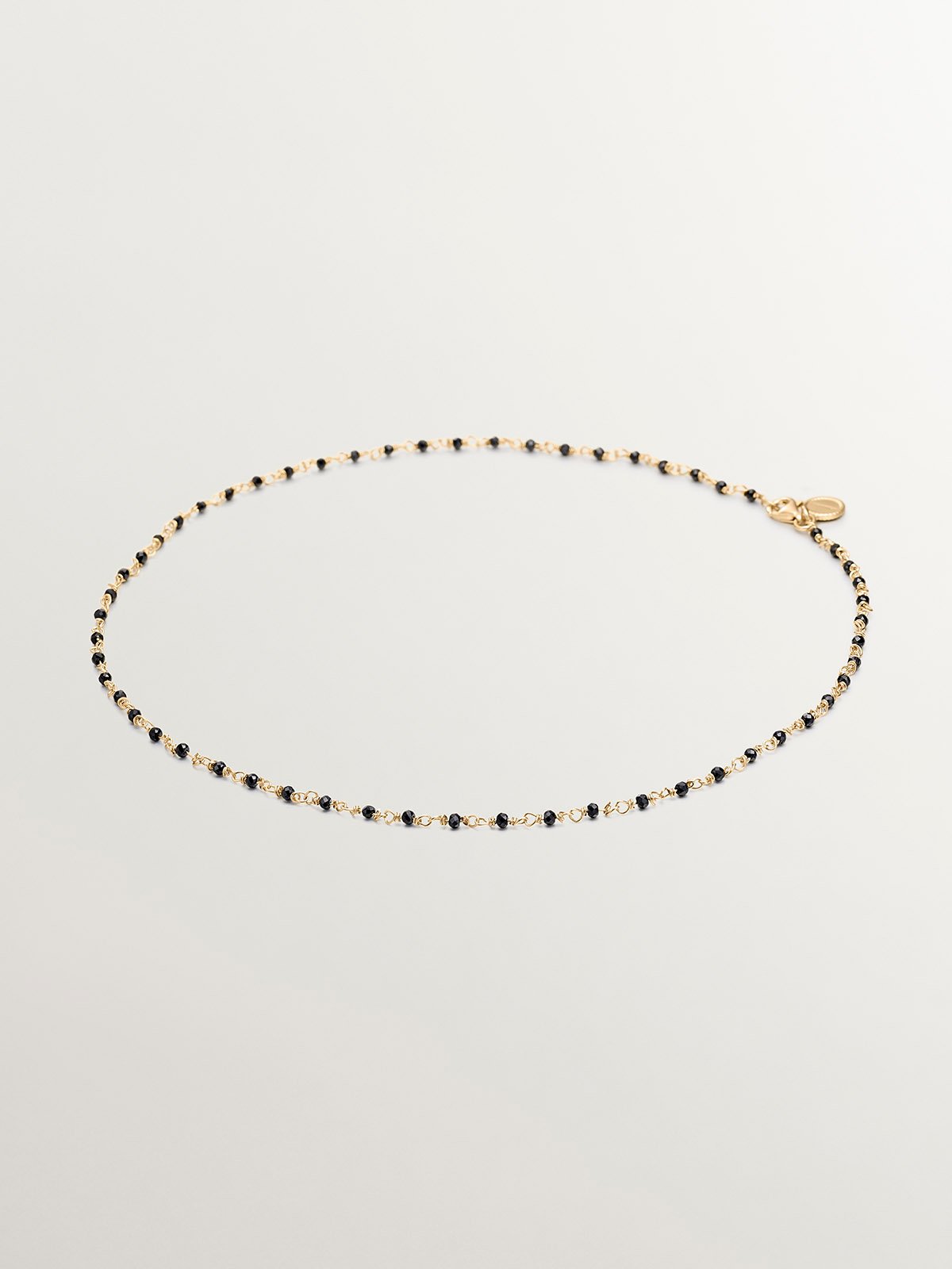 925 Silver chain plated in 18K yellow gold with black spinels.