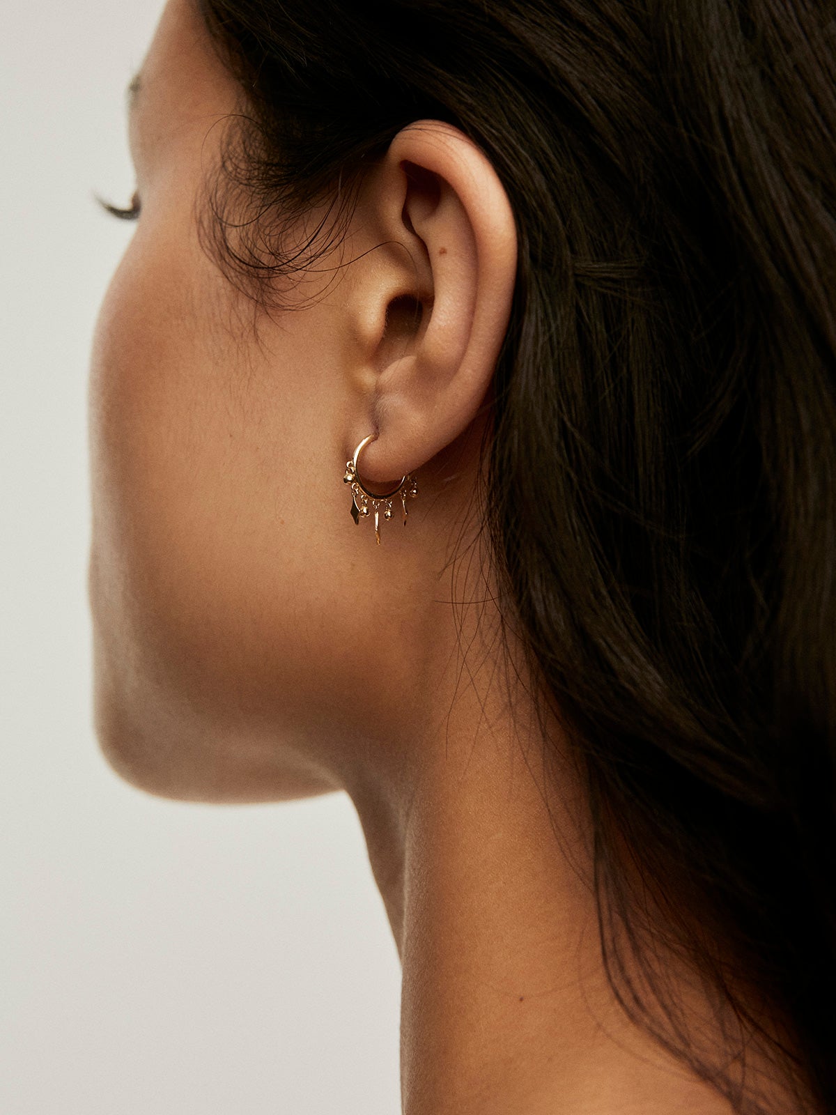 Individual 9K yellow gold hoop earring with spheres and diamonds.