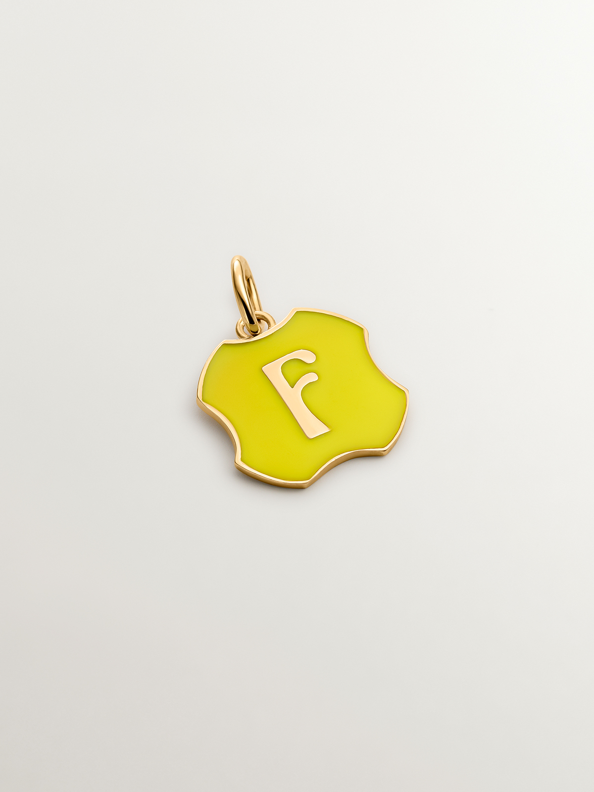 Charm in 925 sterling silver plated in 18K yellow gold with initial F and yellow enamel with irregular shape