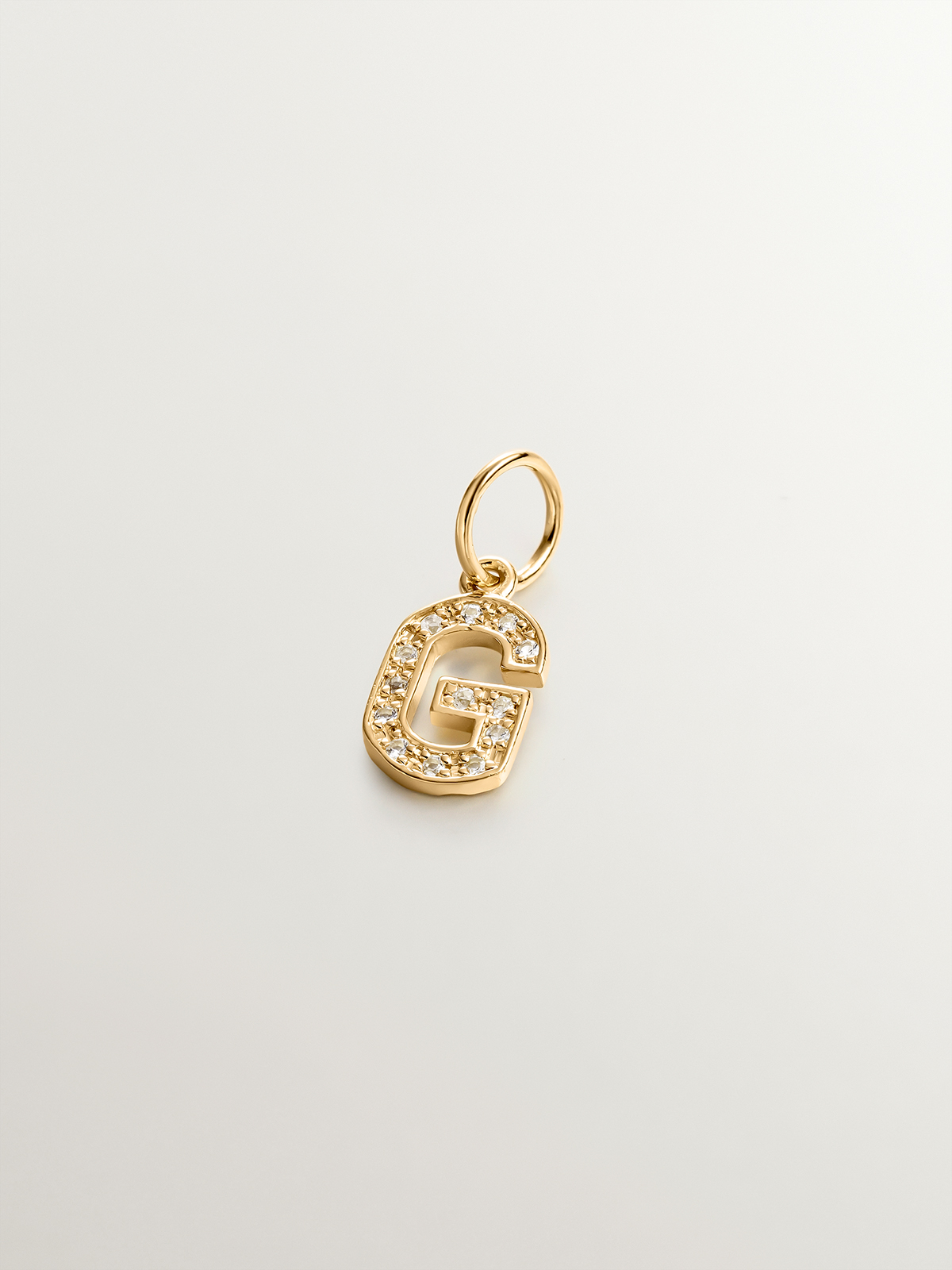 Charm made of 925 silver, bathed in 18K yellow gold and white topaz with the initial G.