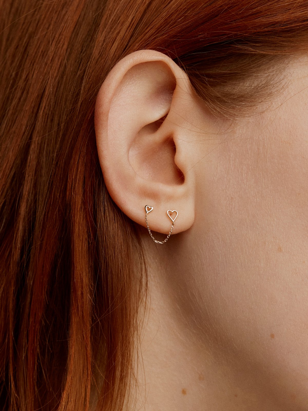 Individual 9K yellow gold climber earring with hearts.