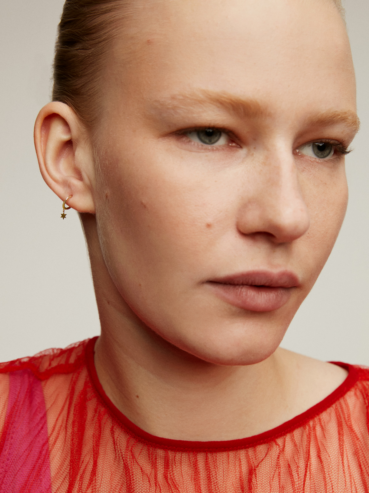 Individual small hoop earring made of 9K yellow gold with a star.