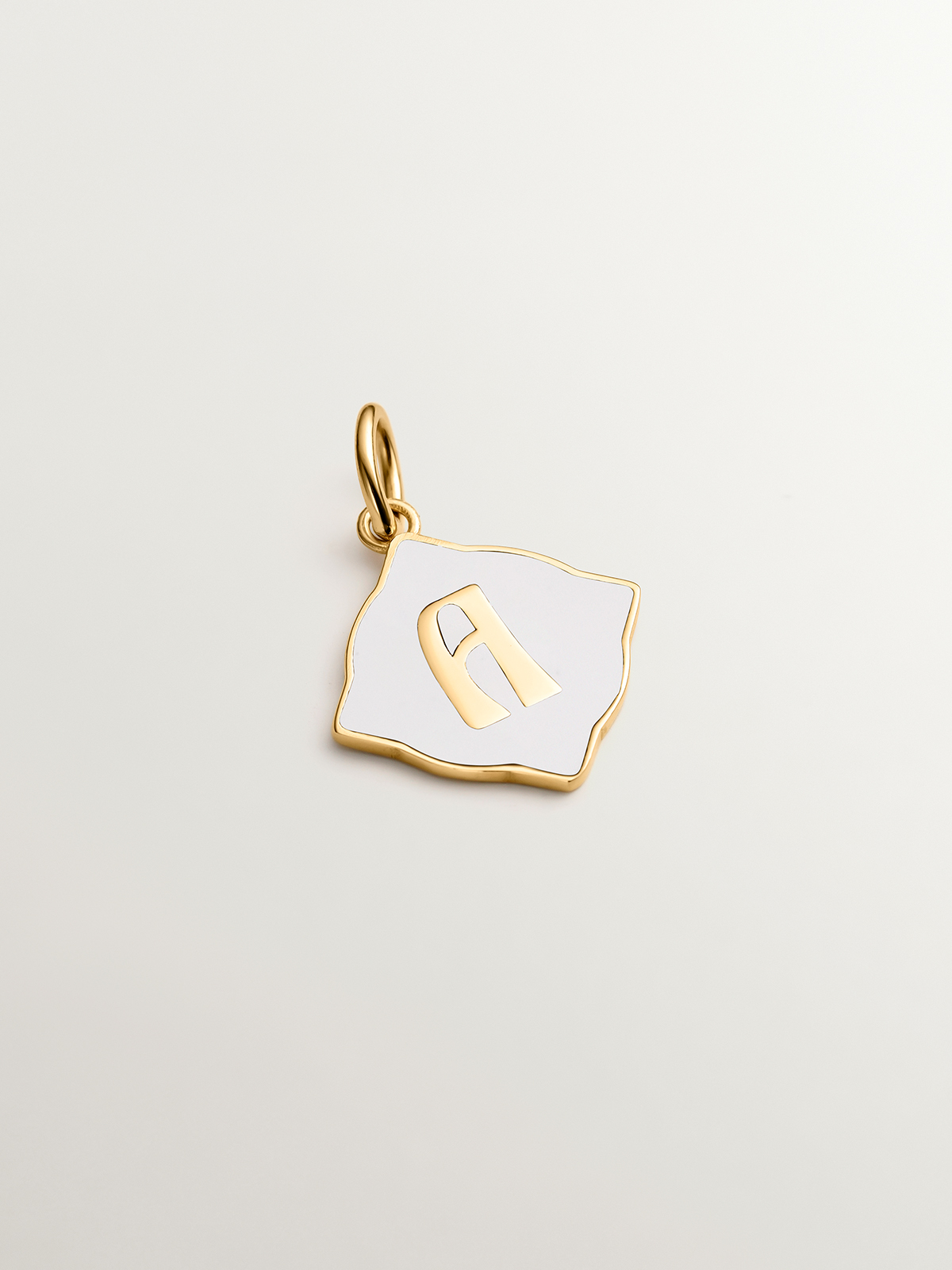 Charm de plata 925 bañada en oro amarillo de 18K con inicial A y esmalte blanco con forma de rombo irregular
