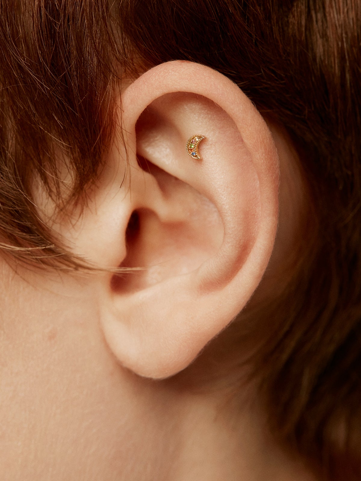 18K yellow gold piercing with multicolor sapphires and moon shape.