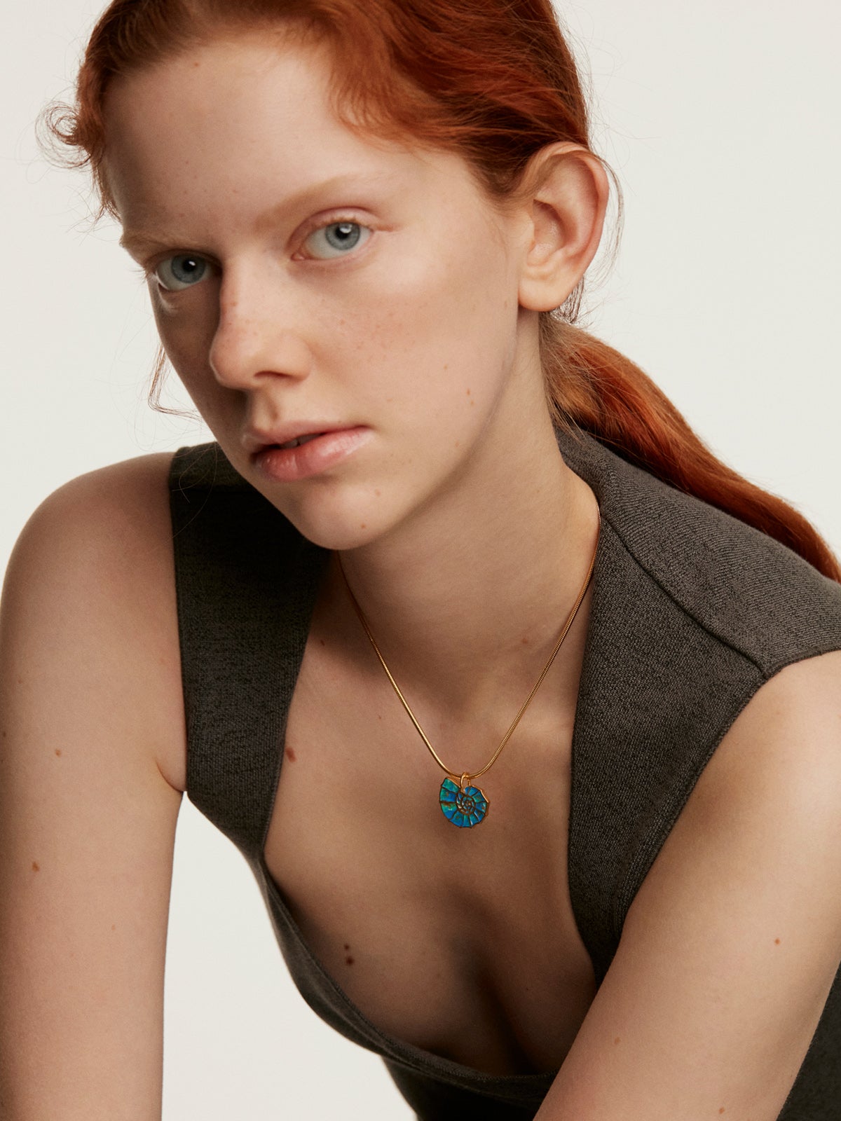 925 silver charm plated in 18K yellow gold with blue enameling and white topazes shaped like a shell.