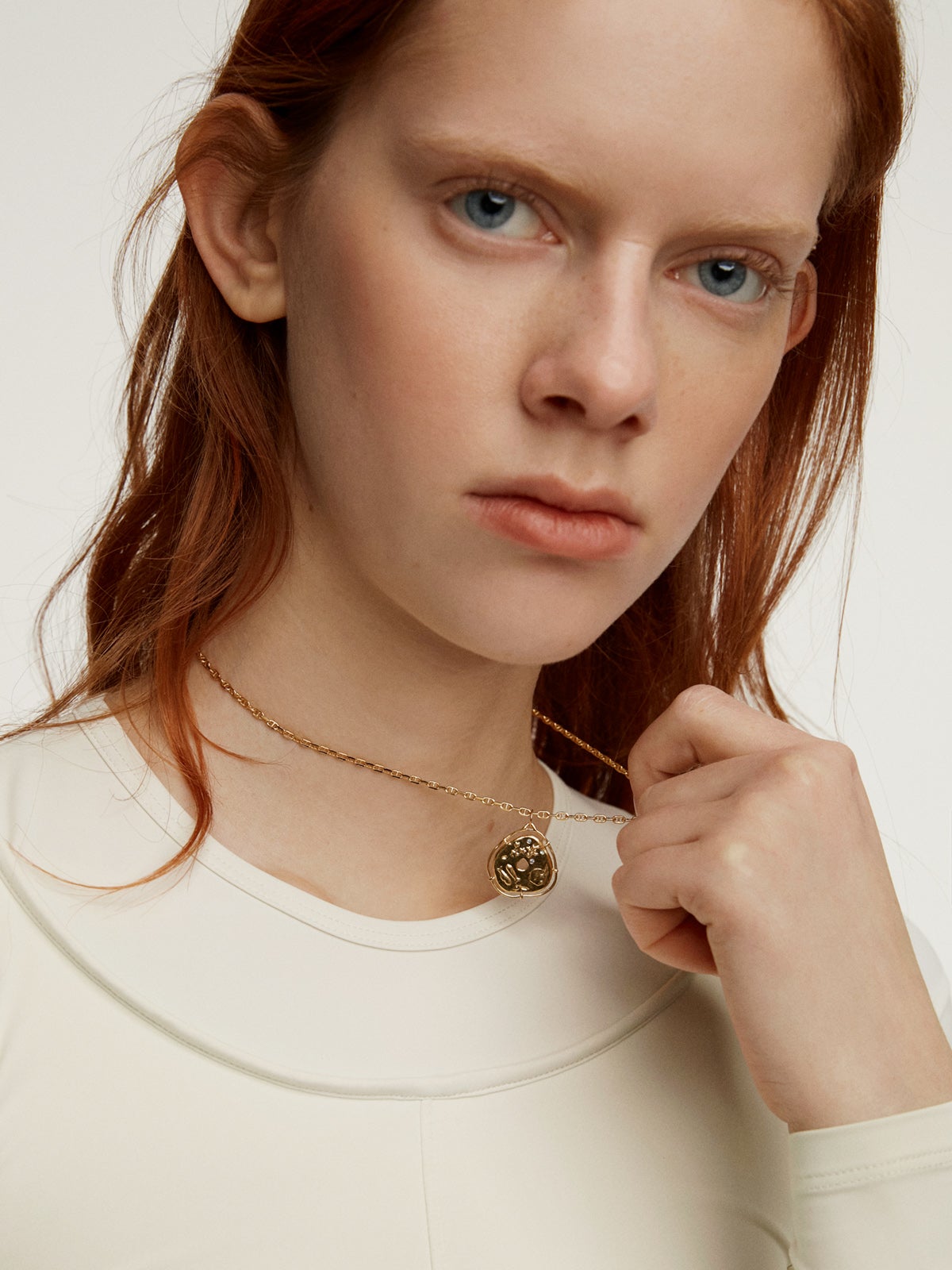 925 Silver charm, gold-plated in 18K yellow gold, with an irregular medallion shape and white topaz stones.
