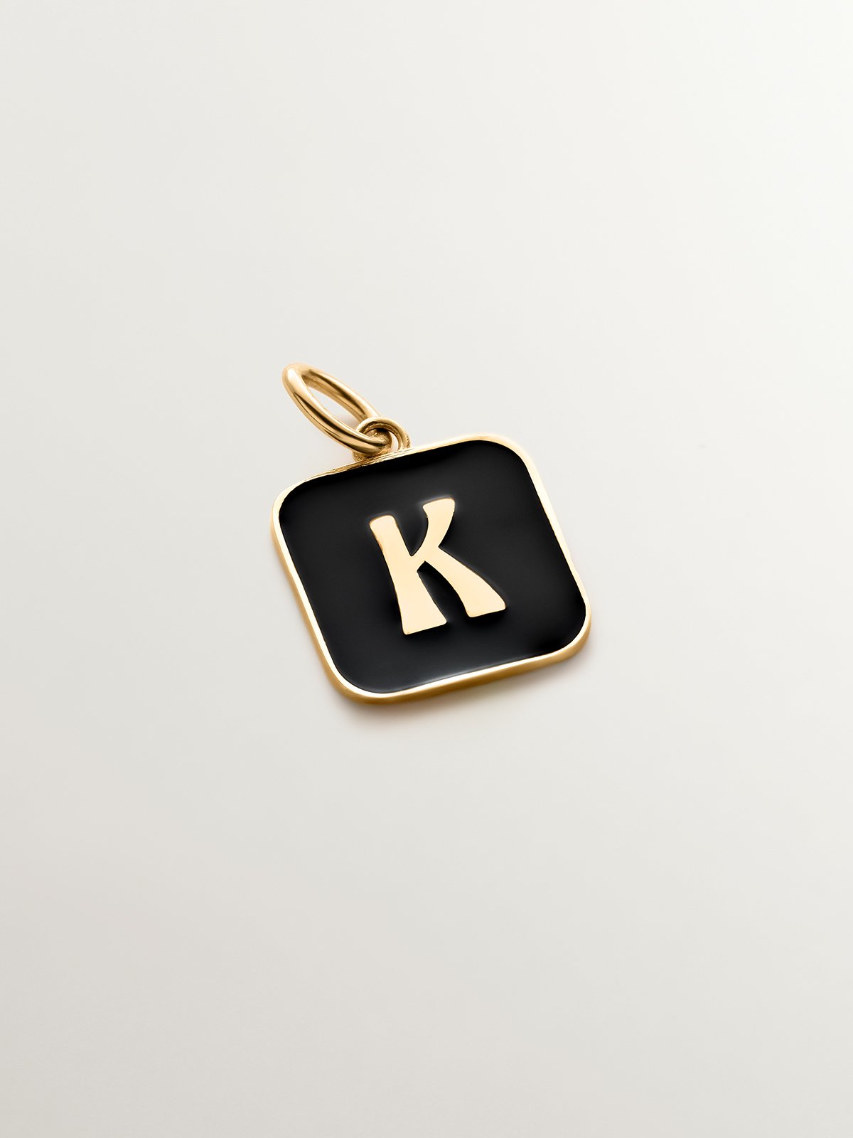 Charm de plata 925 bañada en oro amarillo de 18K con inicial K y esmalte negro con forma cuadrada