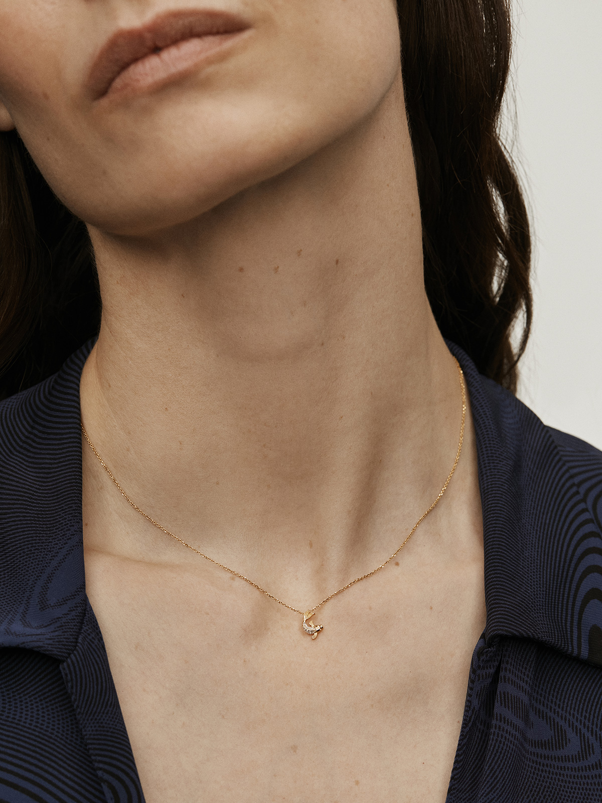 18k yellow gold pendant with diamond-shaped fish.
