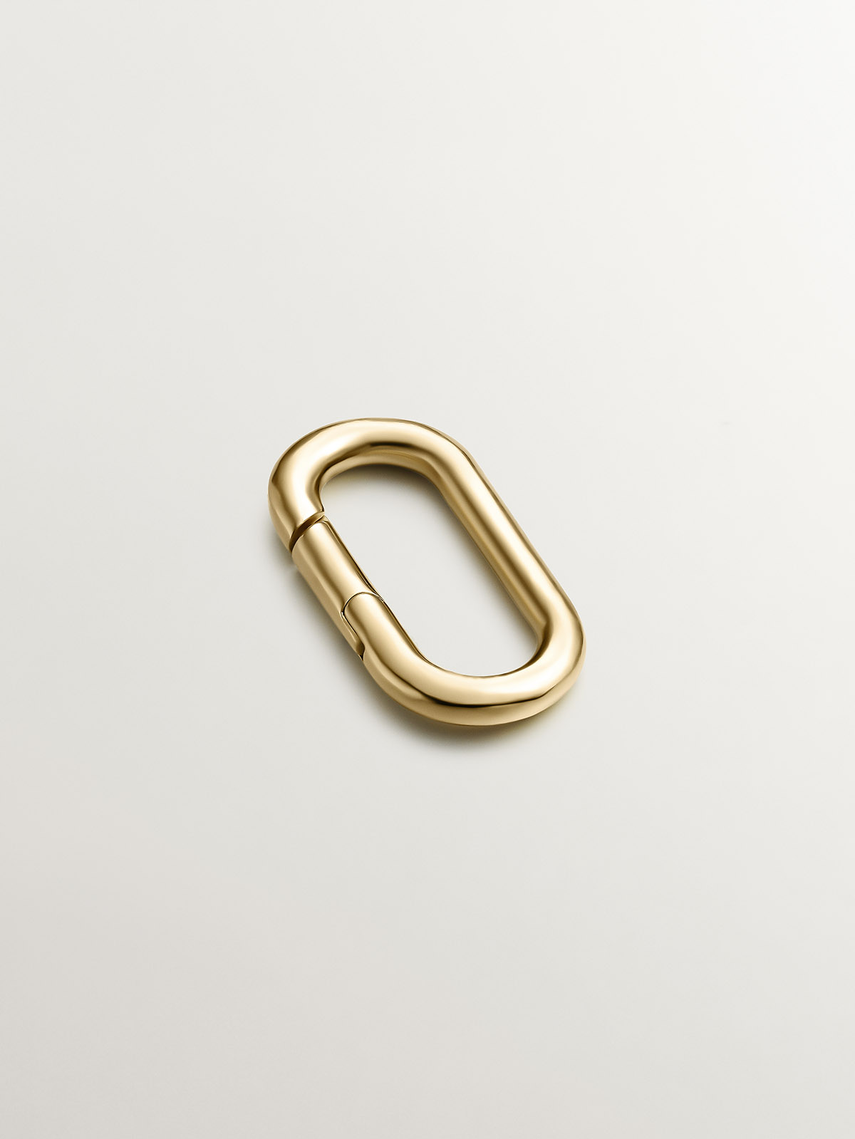 Oval carabiner in 925 silver coated in 18K yellow gold.