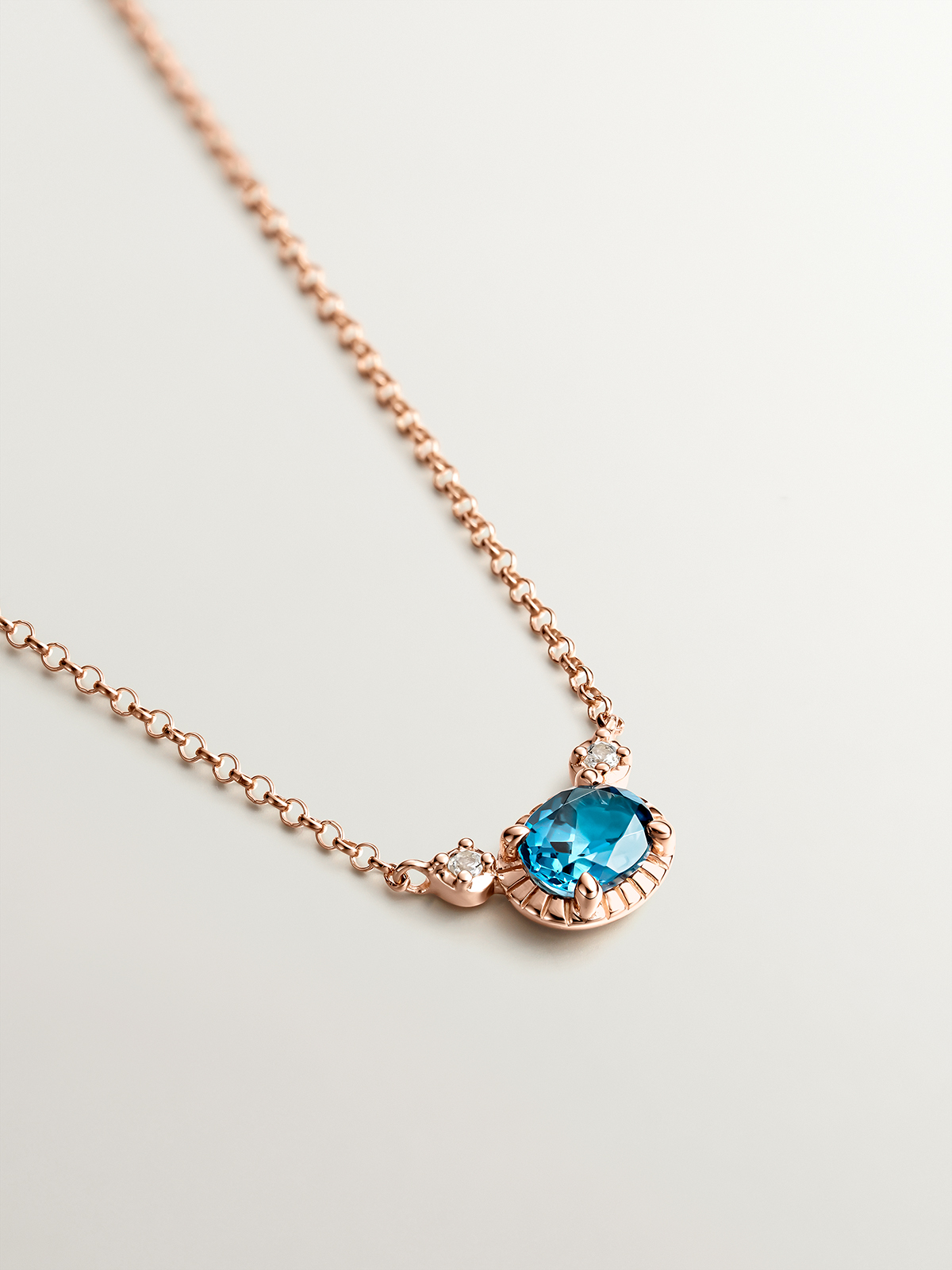 925 Silver pendant dipped in 18K rose gold with London blue and white topazes.
