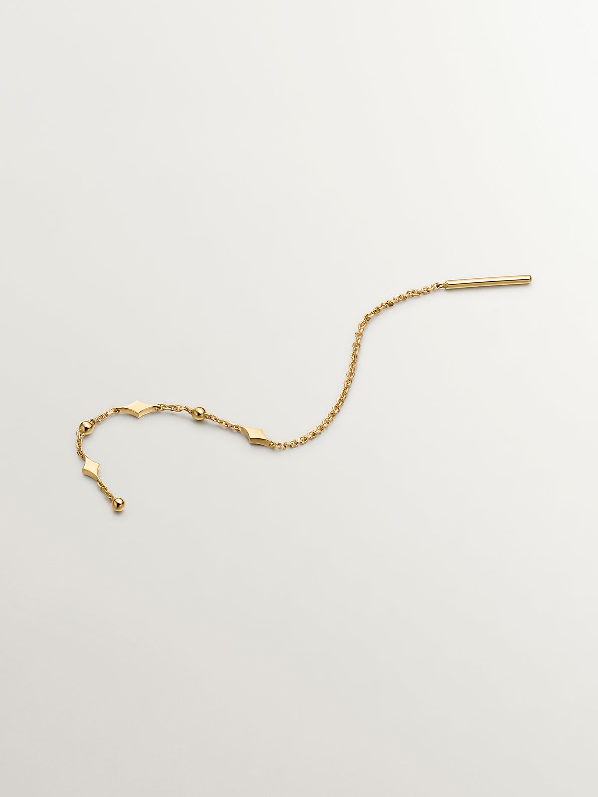 Single 9K yellow gold earring with chain and motifs.