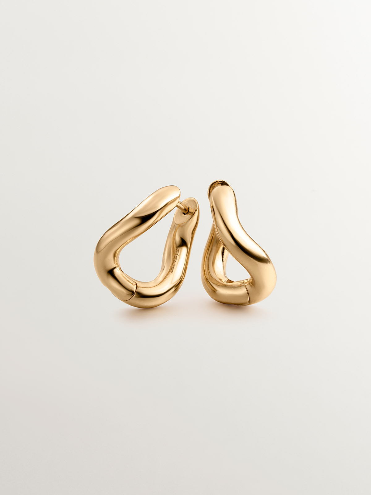Medium thick 925 silver hoop earrings bathed in 18K yellow gold with a wavy shape.