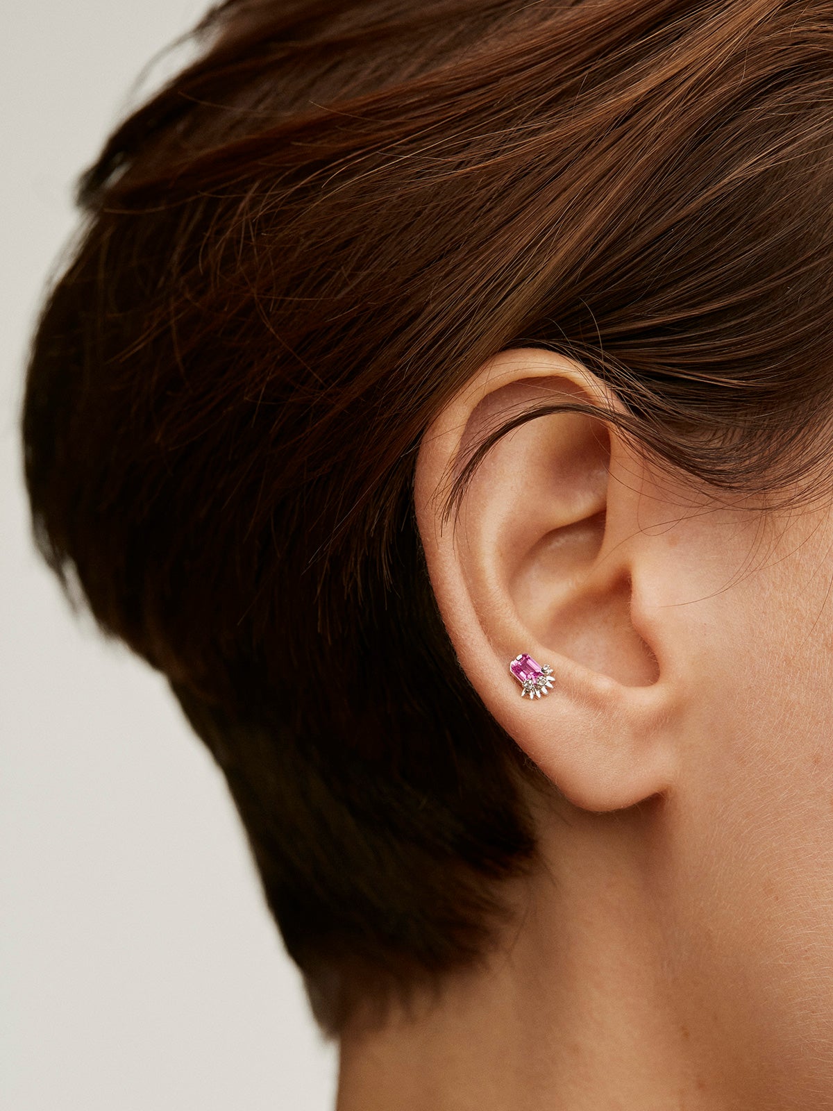 18k white gold piercing with central pink sapphire and diamonds.