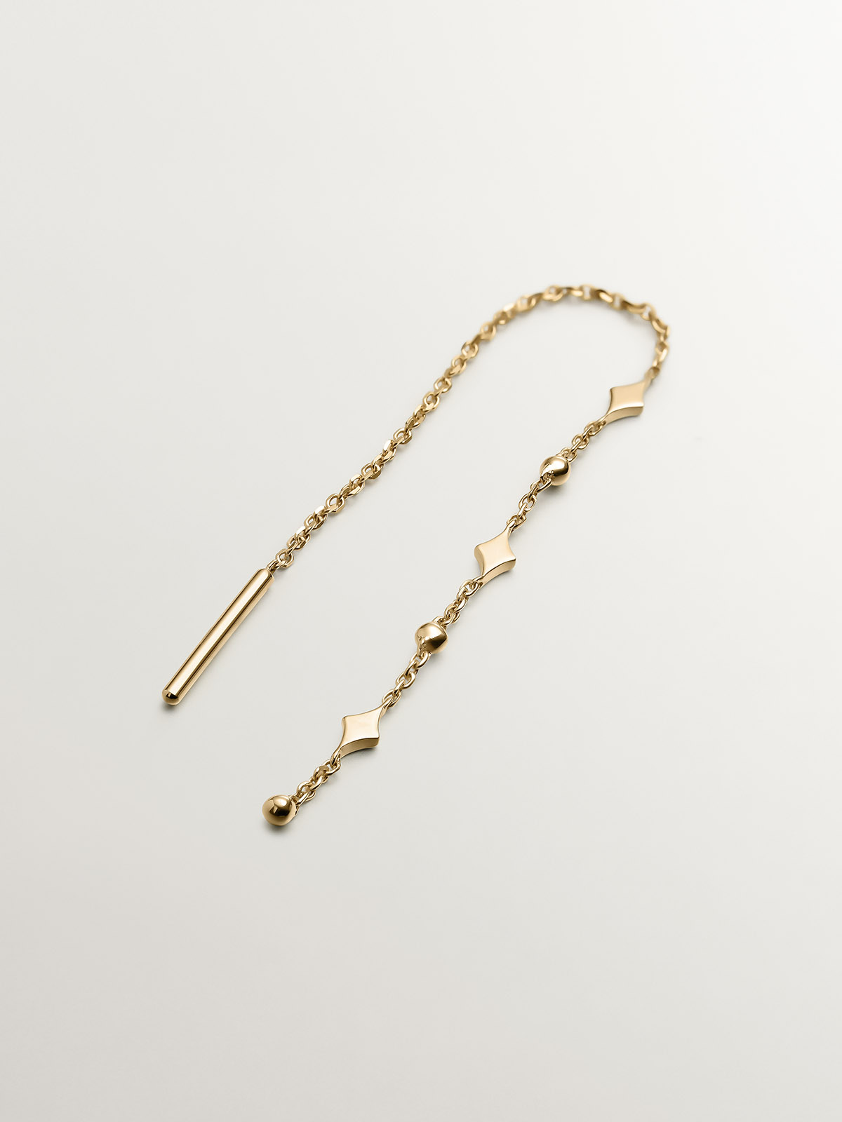 Single 9K yellow gold earring with chain and motifs.