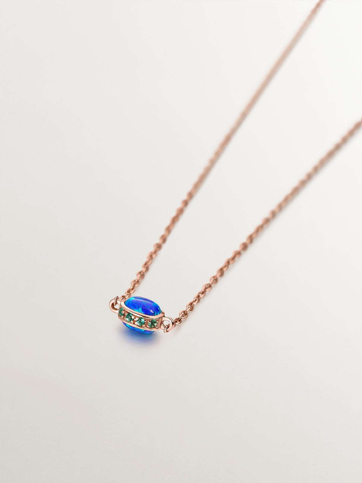 Colgante de oro rosa de 18K con ópalo azul lab grown y esmeraldas