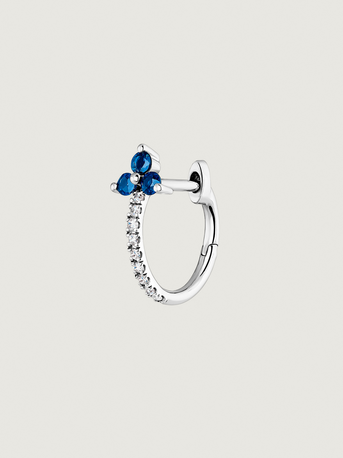 Individual small hoop earring made of 9K white gold with a blue sapphire and diamond clover.
