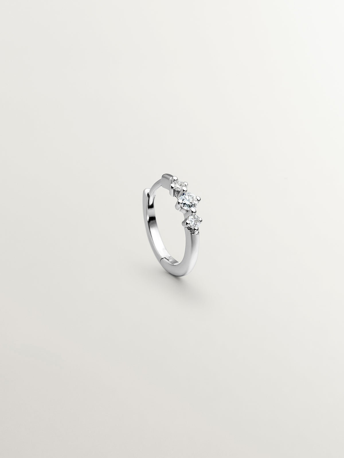 Small individual 18K white gold hoop earring with triple diamond.