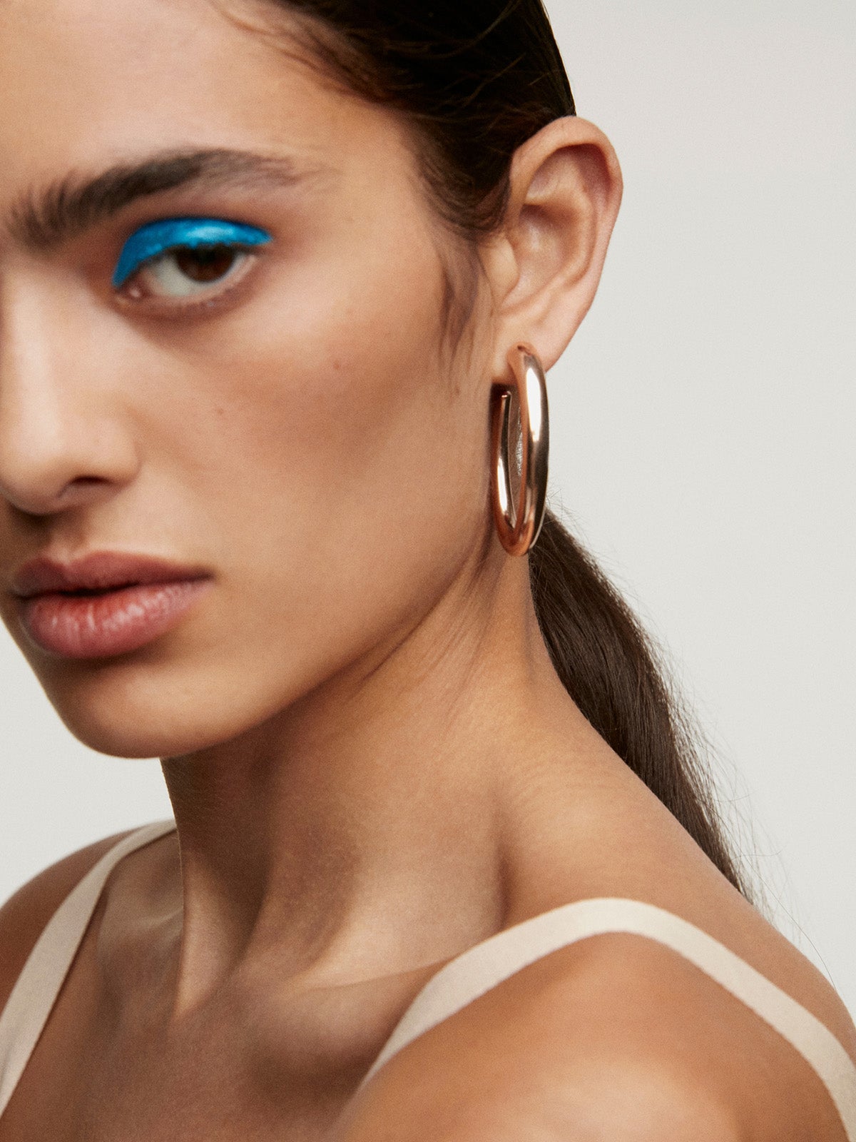 Large hoop earrings made of 925 silver coated in 18K rose gold with an oval shape.
