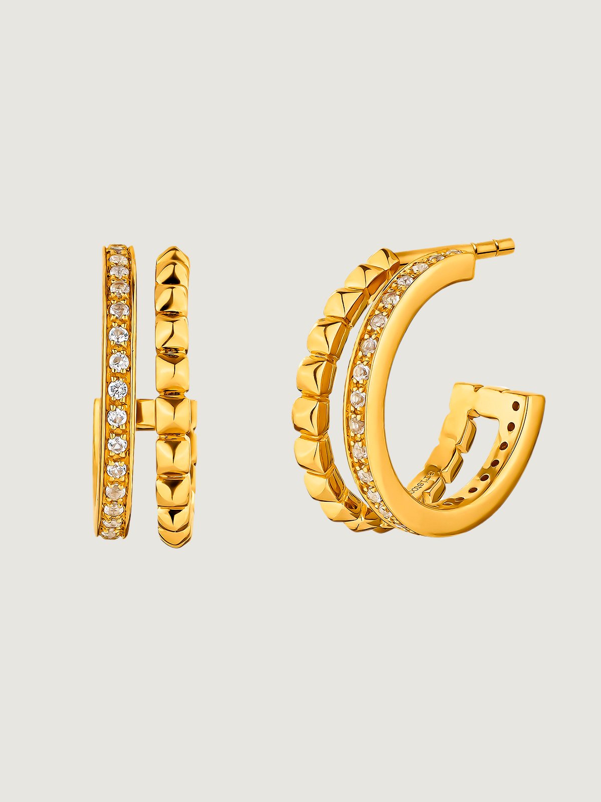 Double hoop earrings made of 925 silver plated in 18K yellow gold with embossing and white topaz.