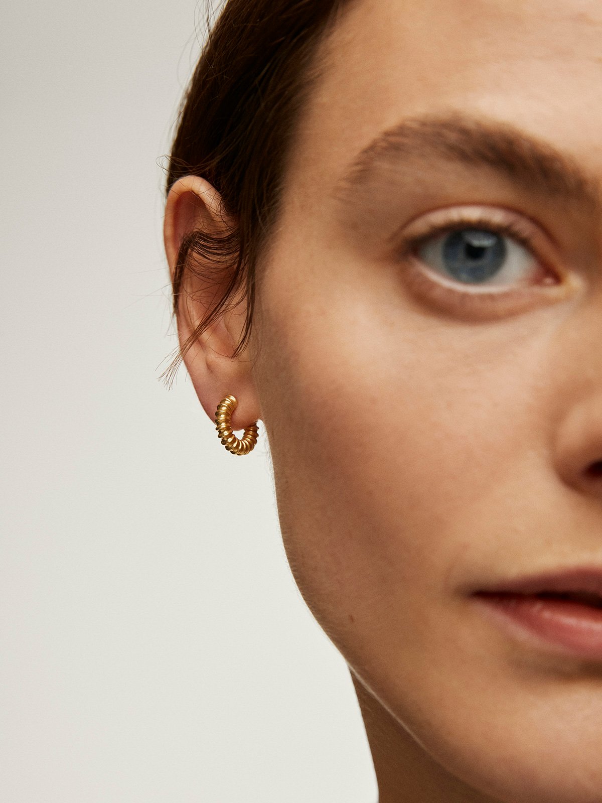 Small hoop earrings made of 925 silver plated in 18K yellow gold with an embossed finish.