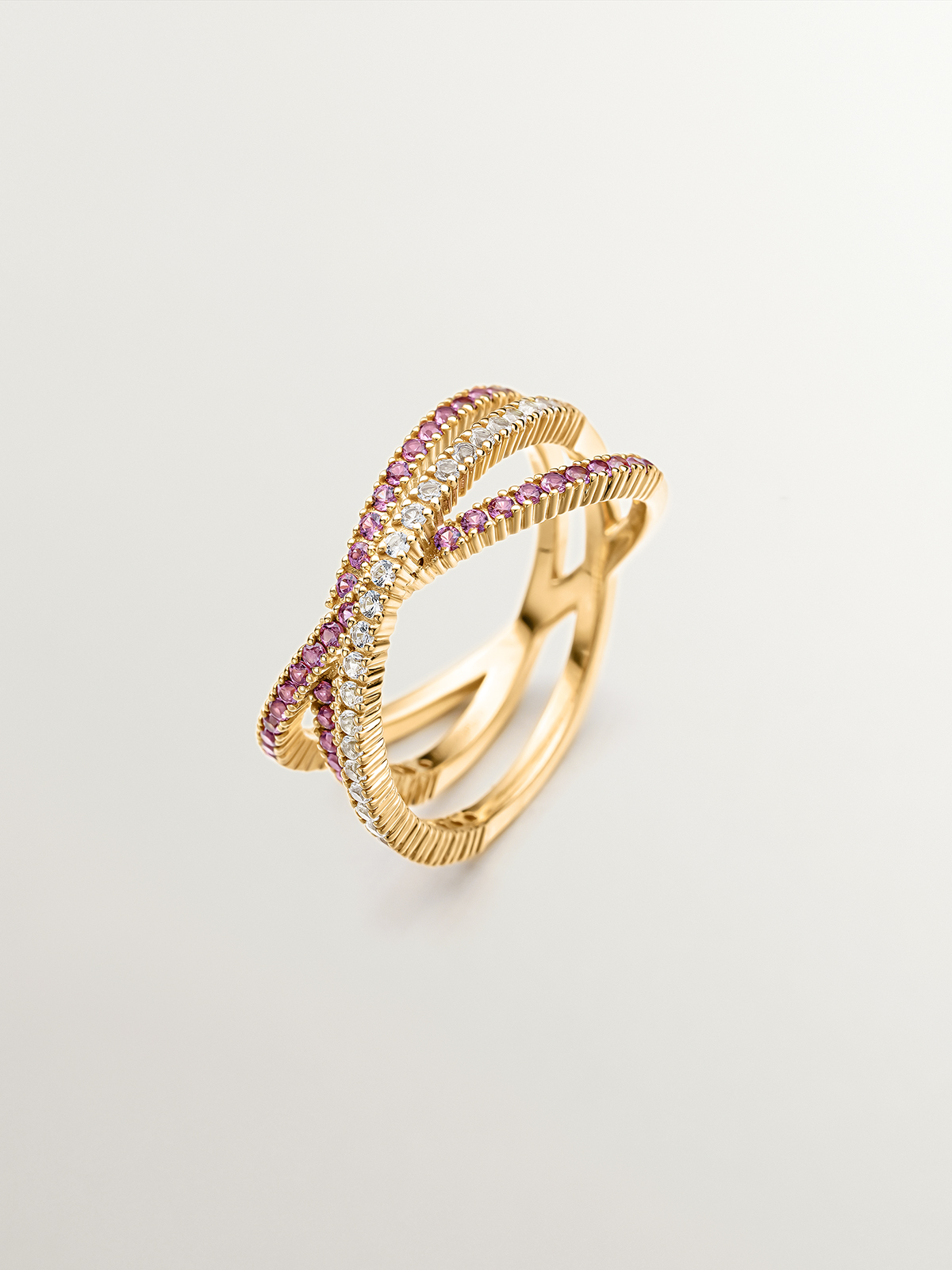 925 Silver triple crossover ring bathed in 18K yellow gold with white topaz and purple rhodolite.