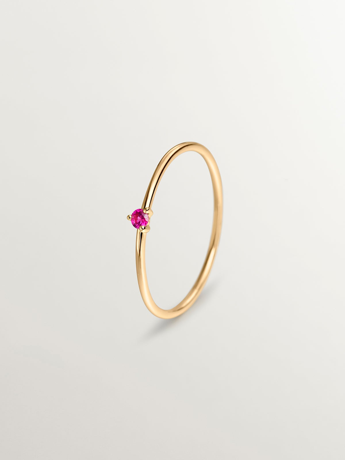 Bague solitaire en or jaune 9K avec rubis rouge.