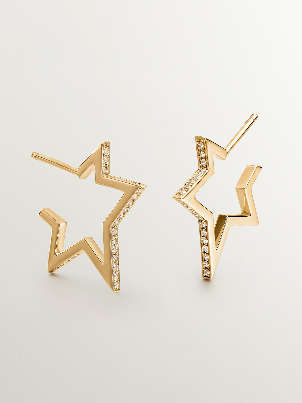 925 Silver earrings bathed in 18K yellow gold in the shape of a star with white topaz.