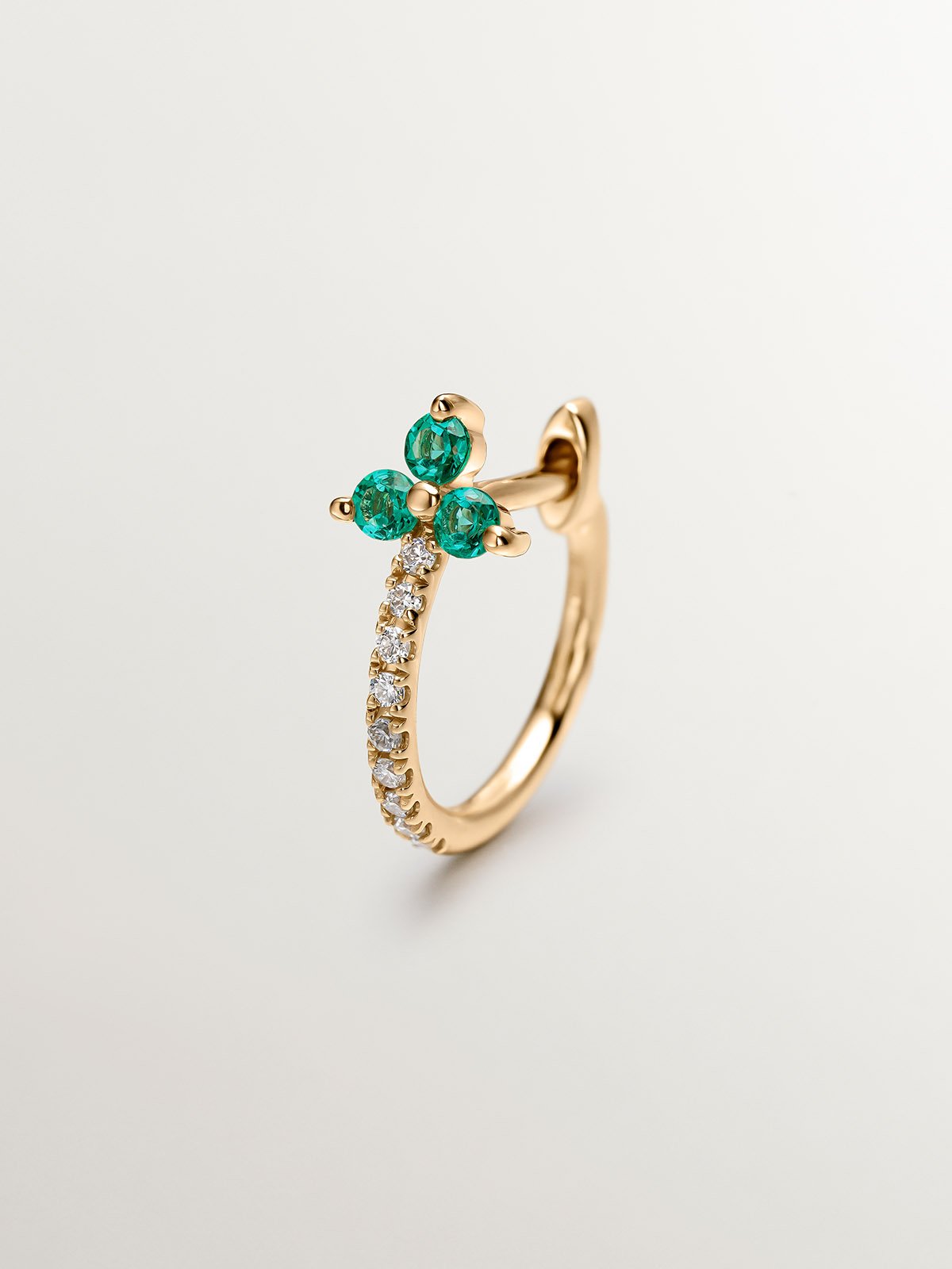 Individual 9K yellow gold earring with diamonds and emeralds.