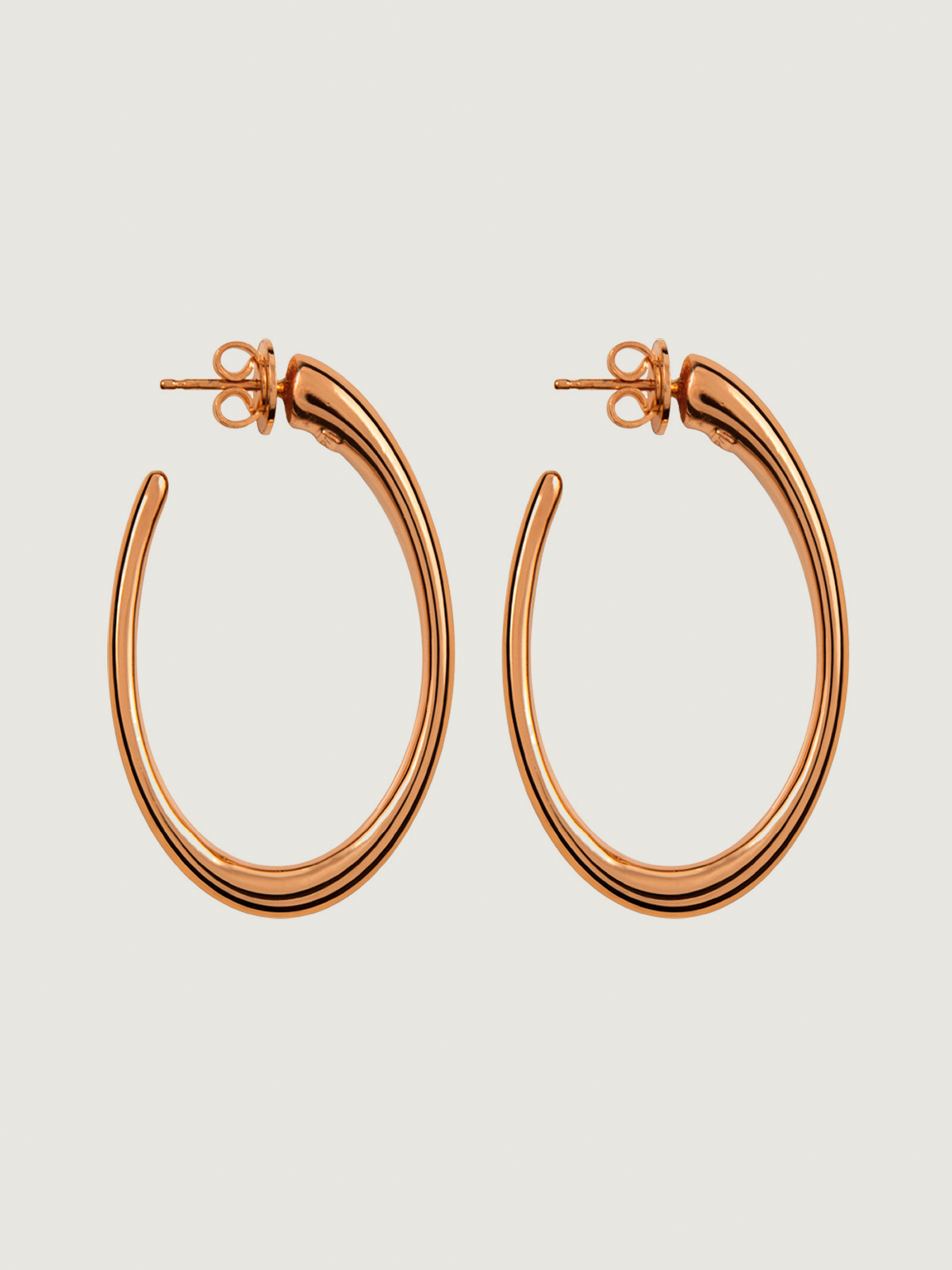Large hoop earrings made of 925 silver coated in 18K rose gold with an oval shape.