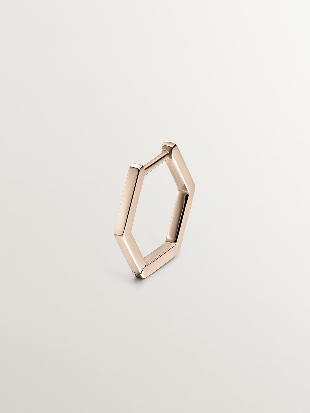 Individual 9K rose gold hoop earring with hexagonal shape.