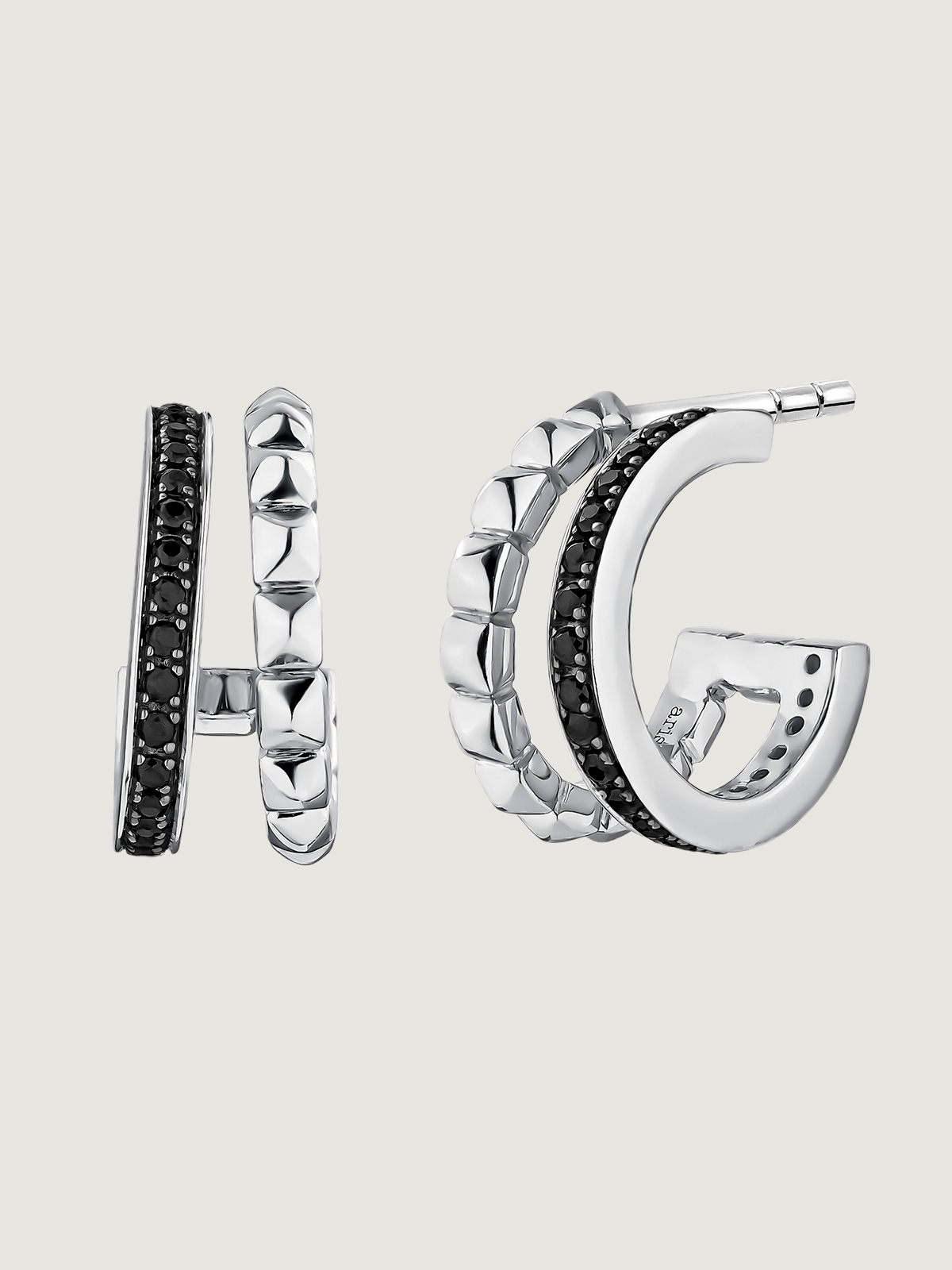 Small double hoop earrings made of 925 silver with embossed detailing and black spinels.