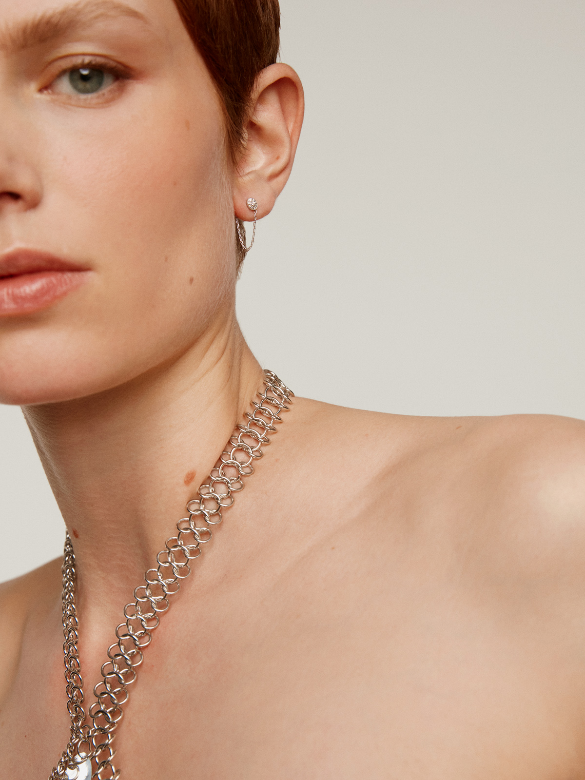 Individual 18K white gold earring with chain and diamonds.