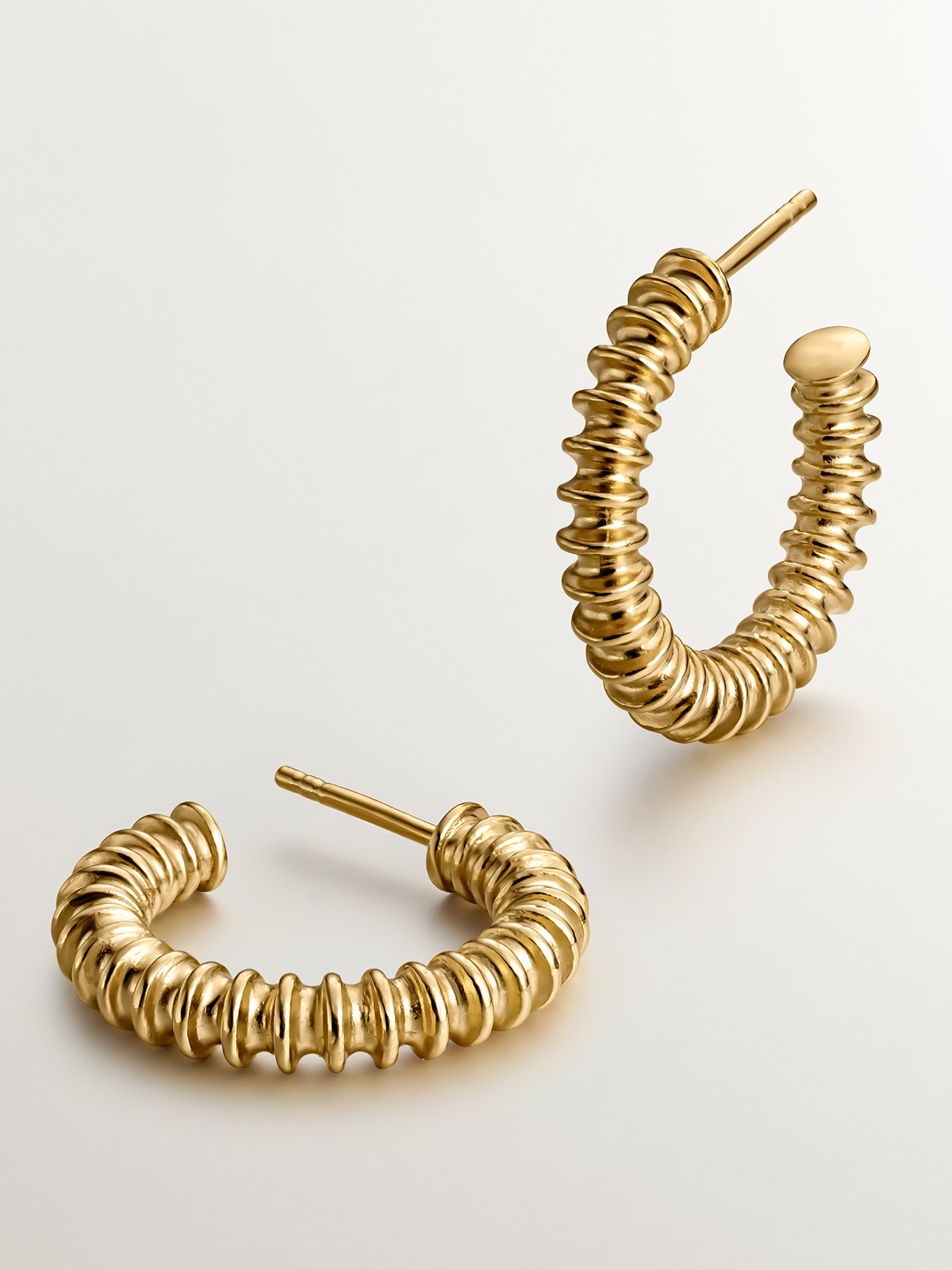 Medium hoop earrings made of 925 silver, coated in 18K yellow gold with a textured finish.