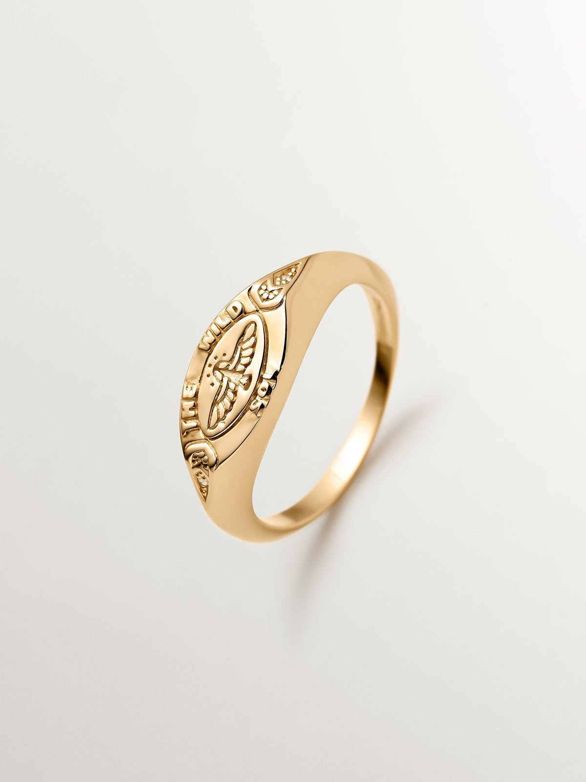 Anillo tipo sello de plata 925 bañada en oro amarillo de 18K con topacios blancos y águila