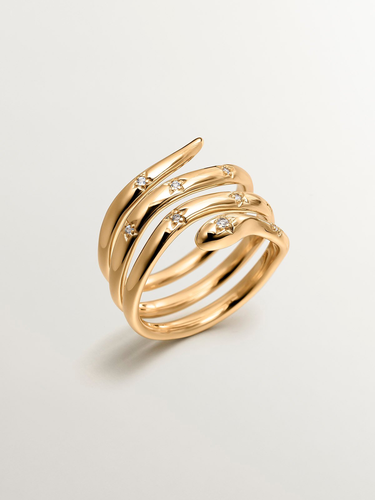925 Silver triple ring bathed in 18K yellow gold with a snake shape and white topazes.