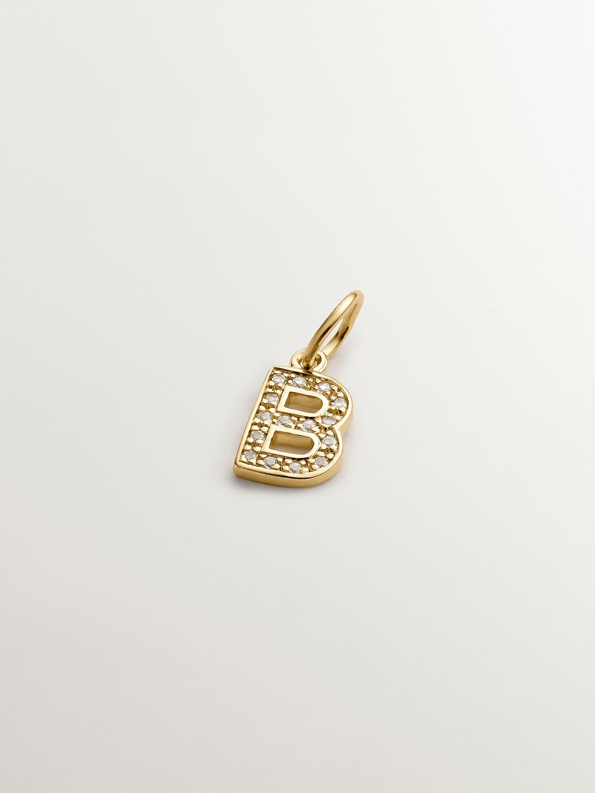 Initial B charm, made of 925 silver coated in 18K yellow gold and adorned with white topaz.