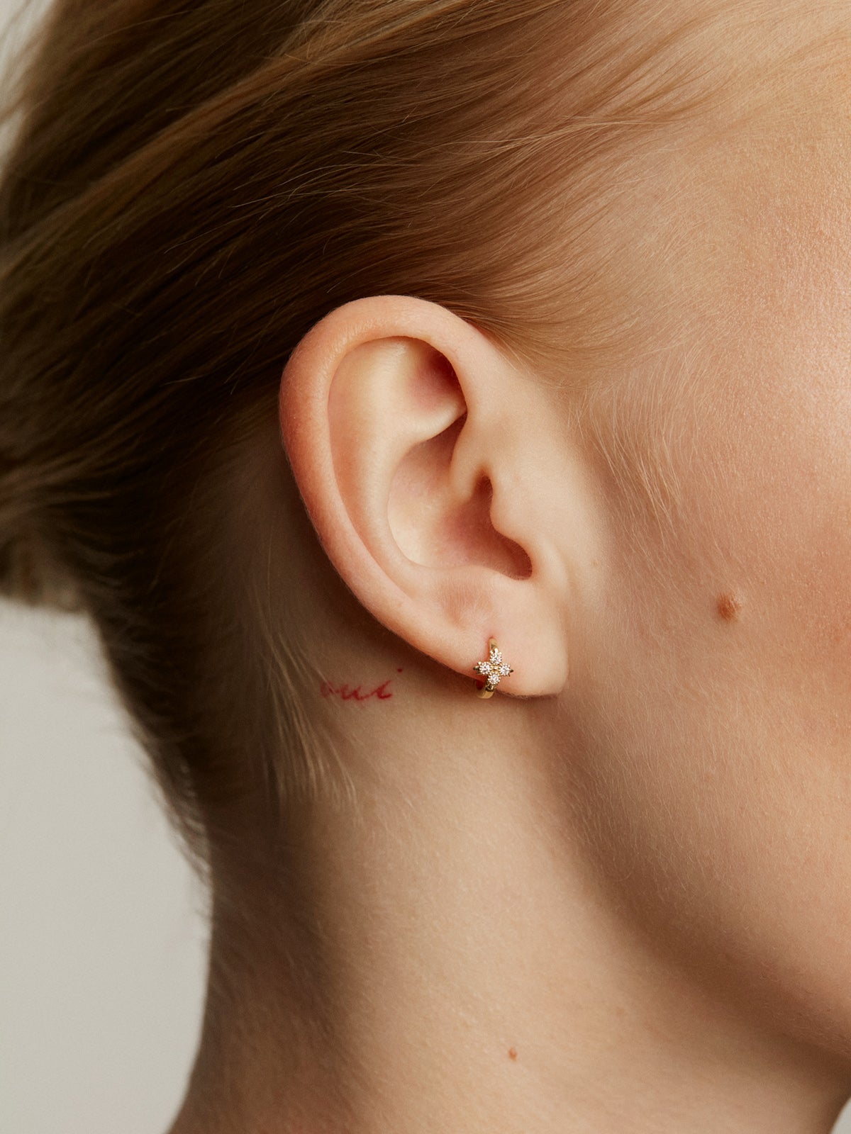 Boucle d'oreille individuelle en petit anneau d'or jaune 9K avec croix de diamants.
