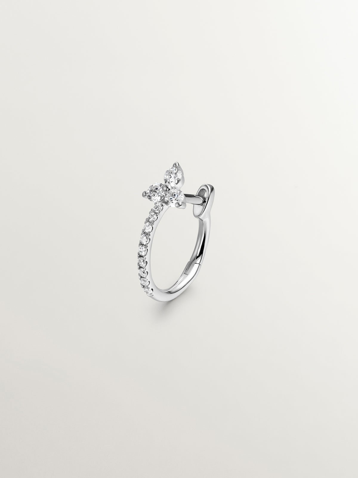 Small single hoop earring made of 18K white gold with diamonds.