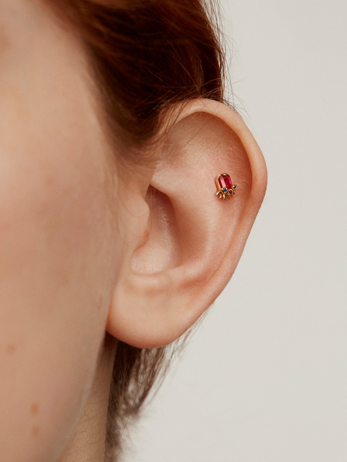 18K Yellow gold piercing with ruby and blue sapphires.