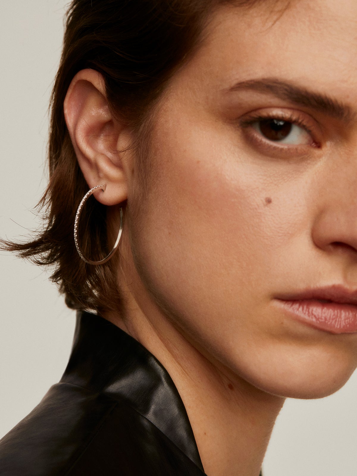 Single large hoop earring made of 18K white gold with diamonds