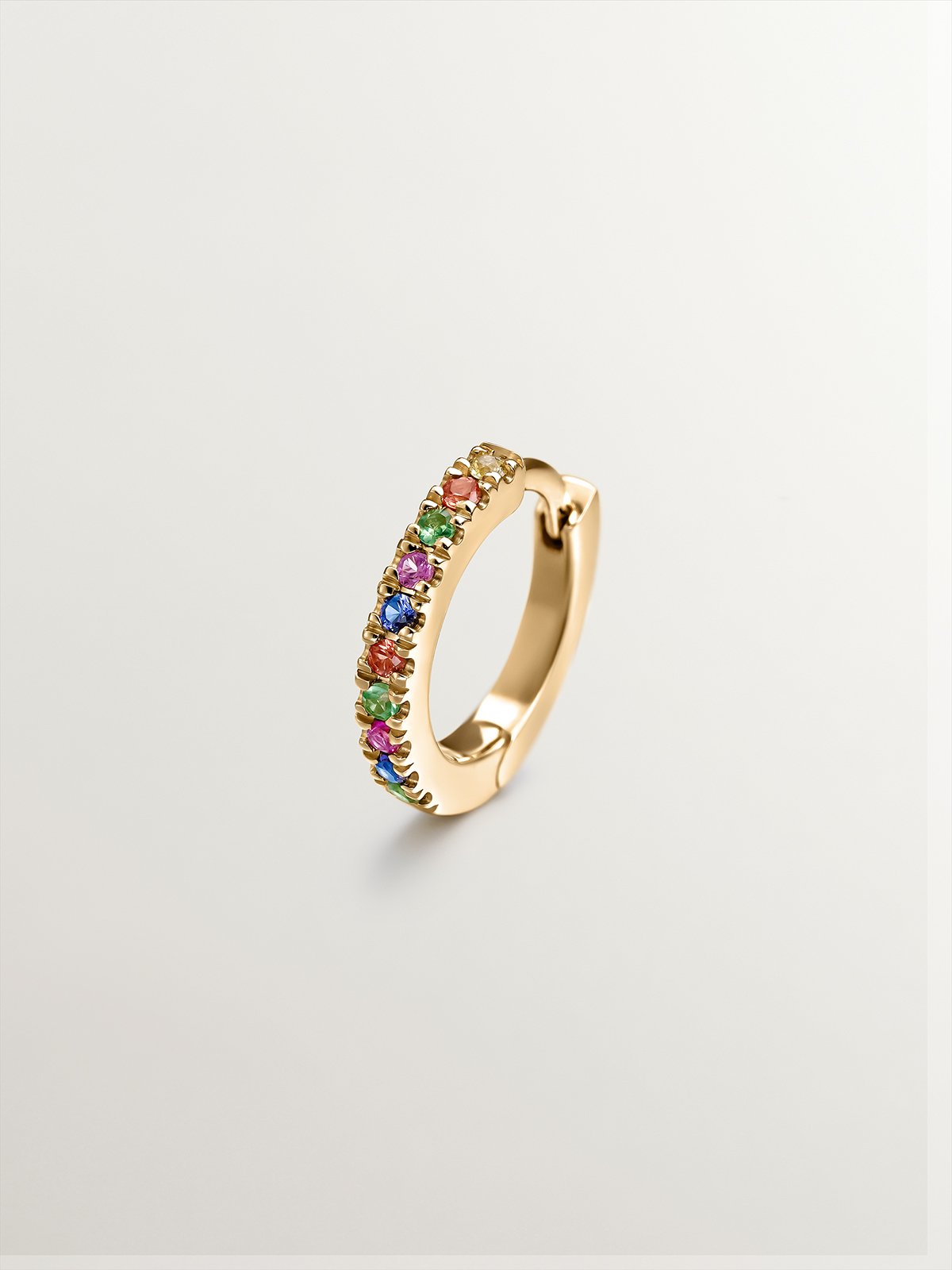 Individual 9K yellow gold hoop earring with tsavorites and multicolor sapphires.