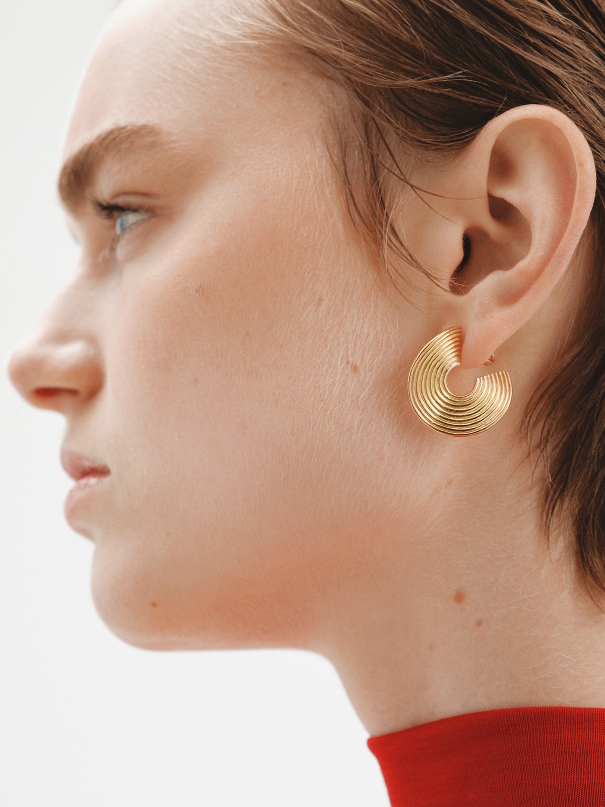 Medium sized hoop earrings made of 925 silver, bathed in 18K yellow gold with texture and irregular shape.