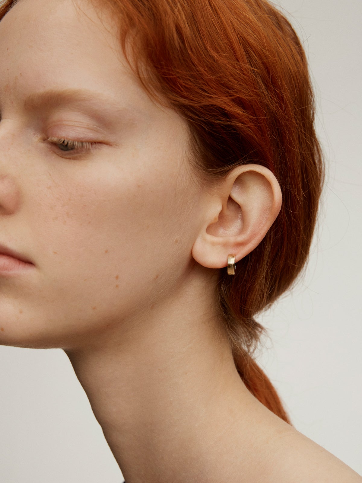 Single wide hoop earring made from 9K yellow gold with texture.